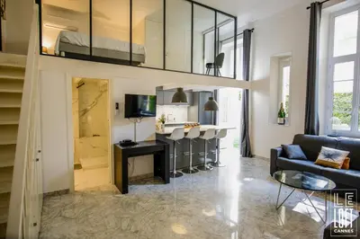 a living room with a couch and a table and a tv at Le loft Cannes in Cannes