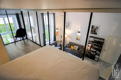 a bedroom with a bed and a living room at Le loft Cannes in Cannes