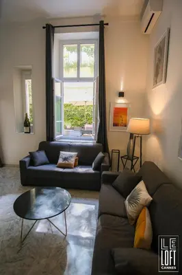 a living room with a couch and a table at Le loft Cannes in Cannes