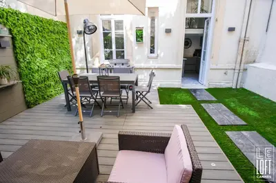 a patio with a table and chairs and grass at Le loft Cannes in Cannes