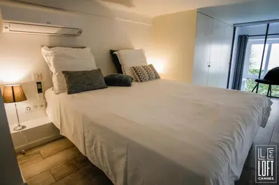 a large white bed in a room with a window at Le loft Cannes in Cannes