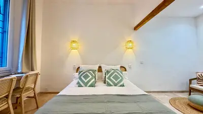 a bedroom with a bed with two lights on the wall at La Bohème Cosy Apt Near Beach AC Near festival in Cannes