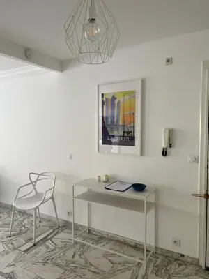 a desk and a chair in a white room at CANNES Martinez- family apartment 100m2 in Cannes