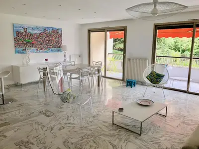 a living room with chairs and a table and a painting at CANNES Martinez- family apartment 100m2 in Cannes
