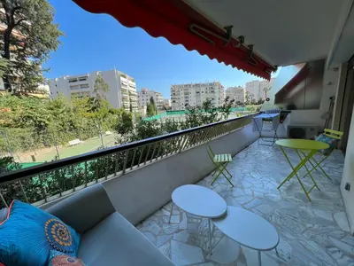 a balcony with tables and chairs and a view of a city at CANNES Martinez- family apartment 100m2 in Cannes