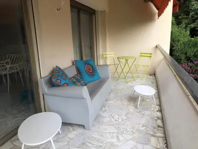 a patio with a couch and chairs and tables at CANNES Martinez- family apartment 100m2 in Cannes