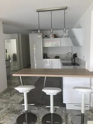 a kitchen with a counter and two bar stools at CANNES Martinez- family apartment 100m2 in Cannes