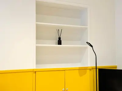 a room with yellow and white shelves and a lamp at L'écrin - 2 pièces - Le Suquet in Cannes
