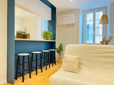 a room with a bed and some bar stools at L'écrin - 2 pièces - Le Suquet in Cannes