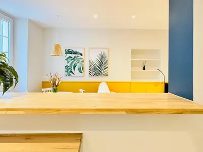 a living room with a yellow and blue wall at L'écrin - 2 pièces - Le Suquet in Cannes