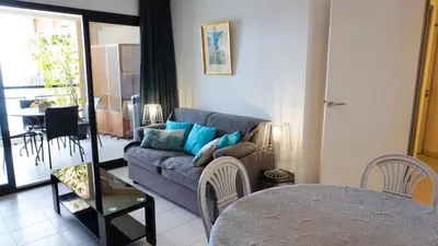 a living room with a couch and a table at Appartement 556, Vue Mer et piscine By Palmazur Vacances in Cannes