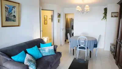 a living room with a couch and a table at Appartement 556, Vue Mer et piscine By Palmazur Vacances in Cannes