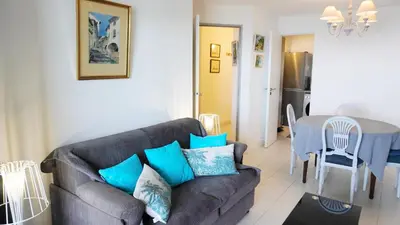 a living room with a couch and a table at Appartement 556, Vue Mer et piscine By Palmazur Vacances in Cannes