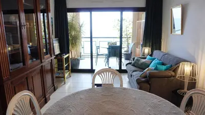a living room with a couch and a table at Appartement 556, Vue Mer et piscine By Palmazur Vacances in Cannes