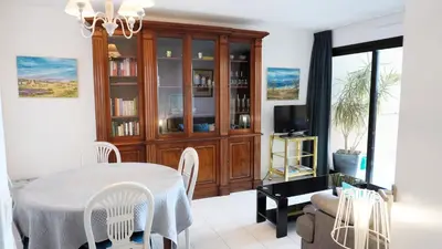a dining room with a table and a tv at Appartement 556, Vue Mer et piscine By Palmazur Vacances in Cannes