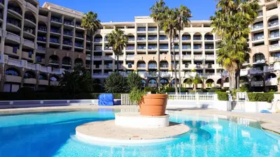 a swimming pool in front of a large building at Appartement 556, Vue Mer et piscine By Palmazur Vacances in Cannes