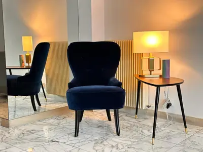 a living room with a blue chair and a table at No.6 La Croisette in Cannes