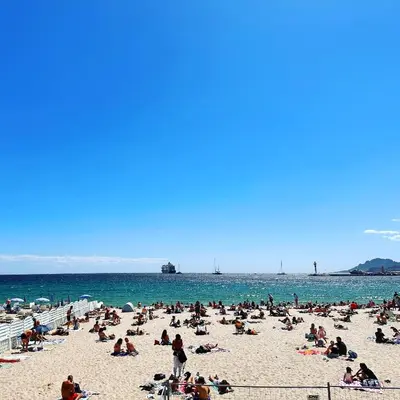 a group of people sitting on a beach at No.6 La Croisette in Cannes