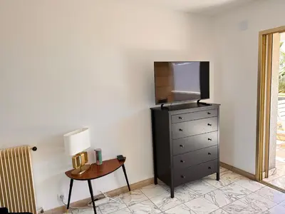 a bedroom with a dresser with a television and a table at No.6 La Croisette in Cannes
