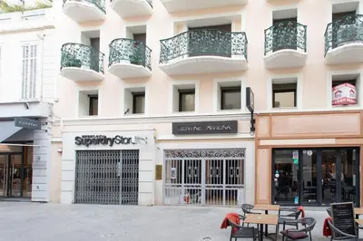 a building with tables and chairs in front of it at C16 - 2 BDR Rue Antibes 4 min Palais Festivals - AC & Terrace in Cannes