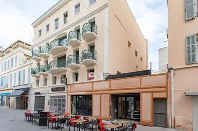 a building with tables and chairs on a street at C16 - 2 BDR Rue Antibes 4 min Palais Festivals - AC & Terrace in Cannes