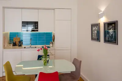 a kitchen with a table with chairs and a vase with flowers at Palais Miramar in Cannes
