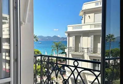 a balcony with a view of the ocean and a building at Palais Miramar in Cannes