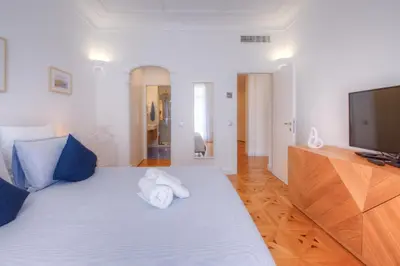a bedroom with a large bed with a flat screen tv at Palais Miramar in Cannes