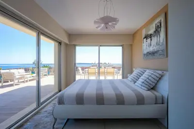 a bedroom with a bed with a view of the ocean at Villa sur le toit - Vue mer exceptionnelle in Cannes