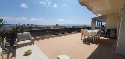 a balcony of a house with a table and chairs at Villa sur le toit - Vue mer exceptionnelle in Cannes