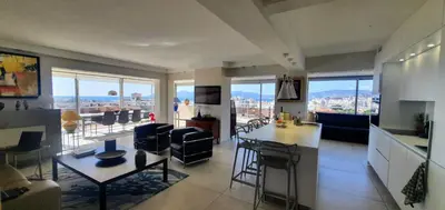 a kitchen and living room with a view of a city at Villa sur le toit - Vue mer exceptionnelle in Cannes