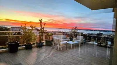 a balcony with a view of the ocean at sunset at Villa sur le toit - Vue mer exceptionnelle in Cannes