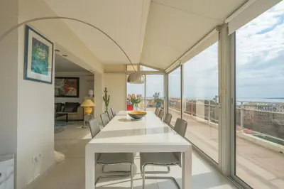 a dining room with a white table and chairs at Villa sur le toit - Vue mer exceptionnelle in Cannes