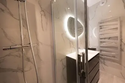 a bathroom with a shower with a sink and a mirror at 06AG - Bel appartement proche Palais des Festivals in Cannes