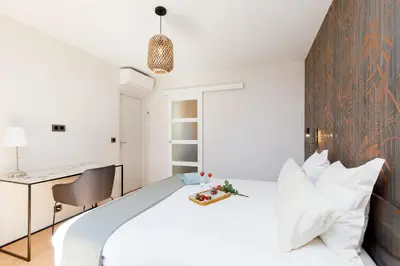 a bedroom with a white bed and a desk at 06AG - Bel appartement proche Palais des Festivals in Cannes