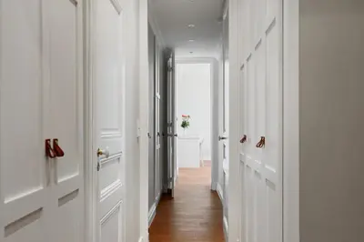 a hallway with white doors and wooden floors at LE SUQUET - Bright renovated and spacious apartment in Cannes