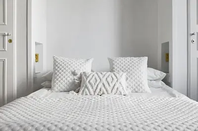a white bed with white pillows and a white bedspread at LE SUQUET - Bright renovated and spacious apartment in Cannes