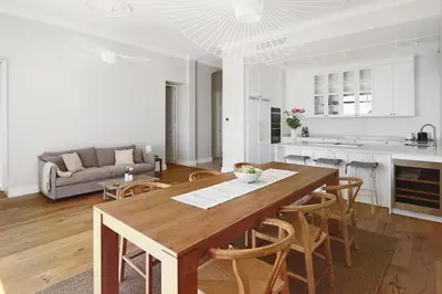 a kitchen and living room with a wooden table and chairs at LE SUQUET - Bright renovated and spacious apartment in Cannes