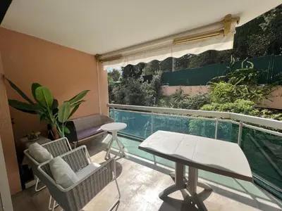 a balcony with a table and chairs and a swimming pool at V Park by Welcome to Cannes in Cannes