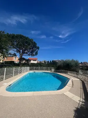 a swimming pool with blue water in a yard at V Park by Welcome to Cannes in Cannes