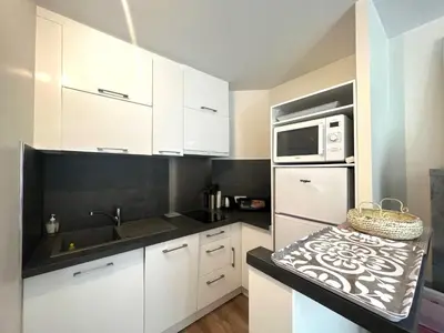 a kitchen with white cabinets and a white microwave at V Park by Welcome to Cannes in Cannes