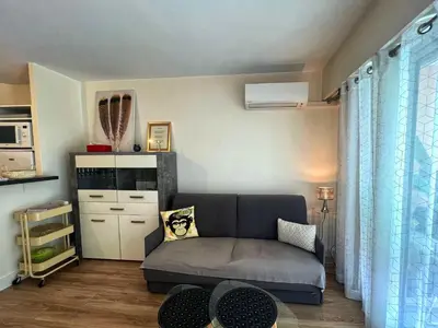 a living room with a couch and a table at V Park by Welcome to Cannes in Cannes