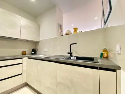 a kitchen with white cabinets and a sink at Palais Azur By SCLS Locations in Cannes
