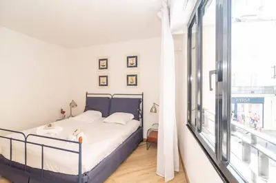 a bedroom with a bed with a dog sitting on it at Cannes Rue d'Antibes Premium 2 BDR 2 baths Exclusive Olam Properties in Cannes