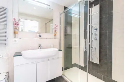 a white bathroom with a sink and a shower at Cannes Rue d'Antibes Premium 2 BDR 2 baths Exclusive Olam Properties in Cannes