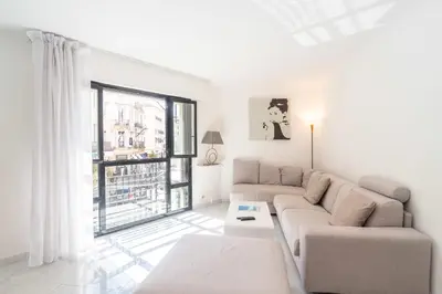 a living room with a couch and a large window at Cannes Rue d'Antibes Premium 2 BDR 2 baths Exclusive Olam Properties in Cannes
