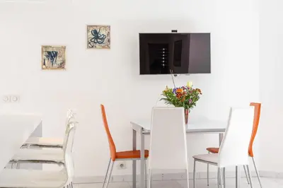 a dining room with white chairs and a table with a vase of flowers at Cannes Rue d'Antibes Premium 2 BDR 2 baths Exclusive Olam Properties in Cannes