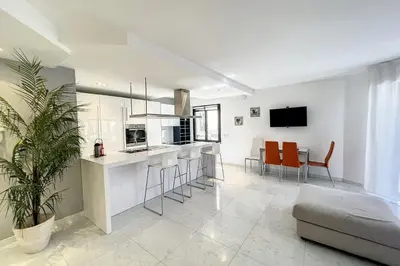 a kitchen and living room with orange chairs and a couch at Cannes Rue d'Antibes Premium 2 BDR 2 baths Exclusive Olam Properties in Cannes