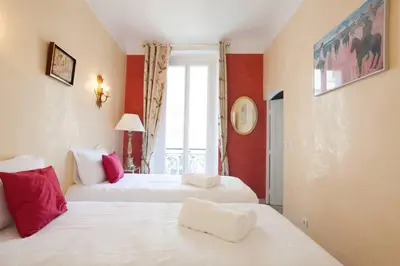 two white beds in a room with red walls at Cannes Meynadier: Superbe appartement trois pièces in Cannes