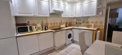 a kitchen with white cabinets and a washing machine at Cannes Meynadier: Superbe appartement trois pièces in Cannes